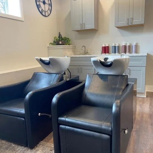 Two reclining shampoo chairs at white basins